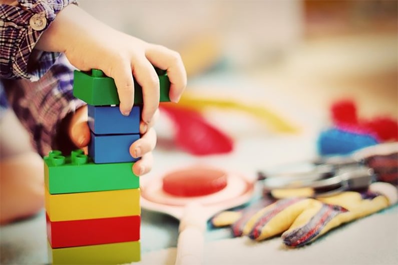 Child's hands are touching the building blocks