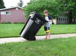 Boy is moving garbage can
